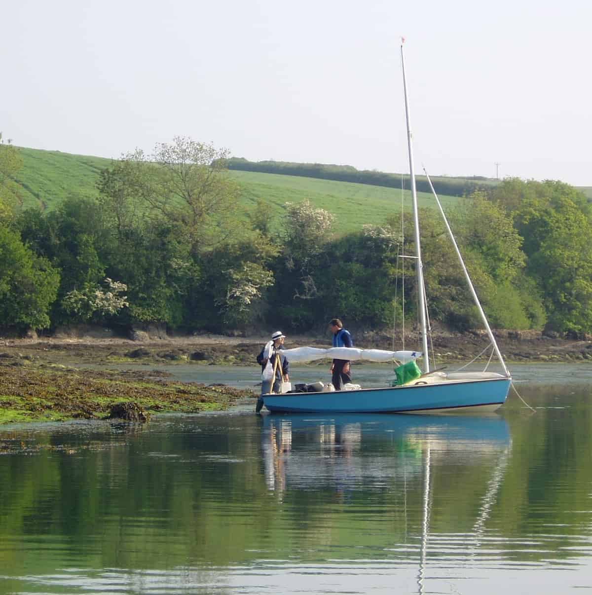 In a peaceful tidal creek, a cruising Wayfarer makes ready to go sailing.