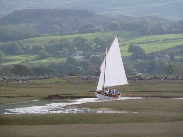 A dinghy explores a creek at Traeth Bach in Wales.