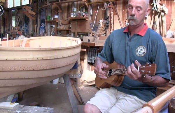 Ned Trewartha, playing the Ukulele he built, in Ned's shed.