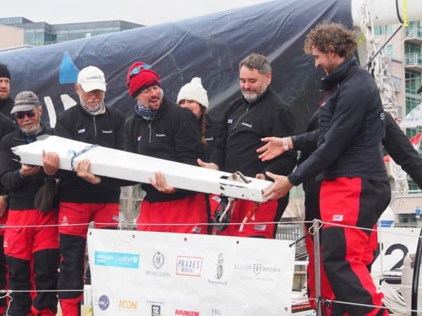 GARMIN crew holds up the broken bowsprit. All repairs were made during the brief stopover, but for the crews and race support staff it was a scramble.