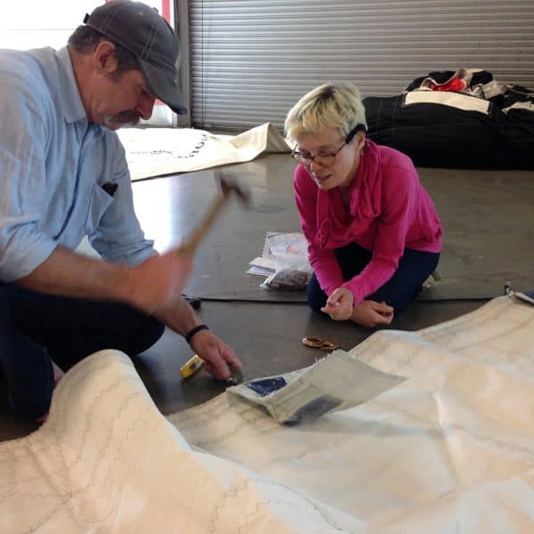 Will Sugg helps Catherine, GARMIN's crewmember in charge of sail repairs.