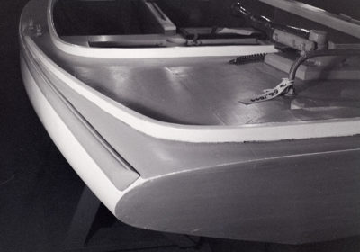 A square-cornered transom can be made elegant by continuing its curve into the deck and adding a steam-bent toe rail above. This boat even has a complimentary curved coaming farther forward.